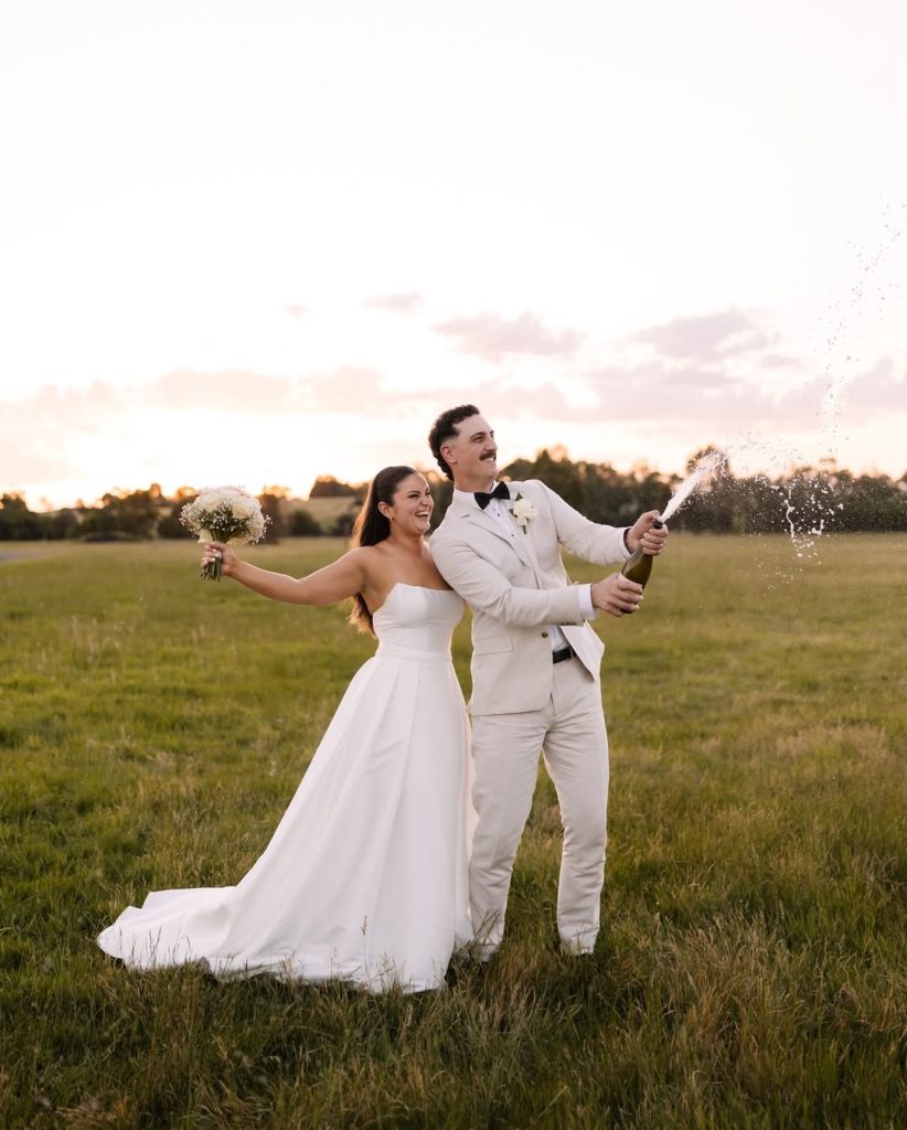 A newly married couple celebrating with sparkling wine