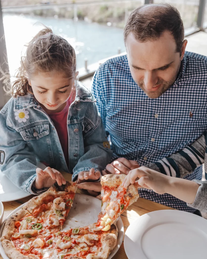 A father and daughter sharing pizza at Rochford